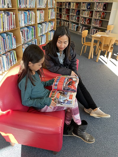 photo of woman and child reading a book